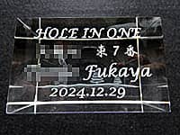 「Hole in one、達成者の名前、達成日の日付」を側面に彫刻した、ホールインワンの記念品用のガラス製オブジェ