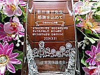 「○○先生 感謝を込めて ○○保育園保護者会一同、先生と保育園児のイラスト」を彫刻した、卒園児の保護者会から保育園の先生へ贈る花瓶