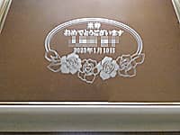 「米寿おめでとうございます 贈る相手の名前 88歳の誕生日の日付」を表面に彫刻した米寿祝い用の鏡