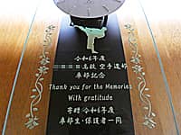 空手の蹴りのイラストを前面ガラスに彫刻した、卒部生から空手道部に寄贈する壁掛け時計