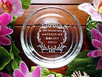 「50th anniversary、周年記念日の日付」を底面に彫刻した、会社の50周年祝い用のガラス製灰皿