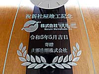 「祝新社屋竣工記念、贈り先のロゴマーク、日付、贈り主の会社名」を彫刻した新社屋竣工記念用の壁掛け時計