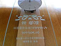 「祝開院 ○○クリニック、日付、贈り主の名前」を彫刻した整形外科クリニックの開院祝い用の名入れ掛け時計